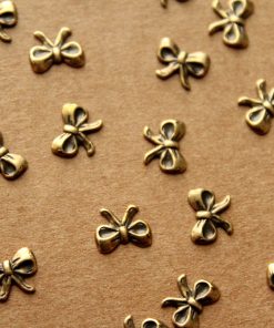 16 pc. Tiny Antique Brass Plated Tied Bows: 7.5mm by 5mm - made in USA | AB-114